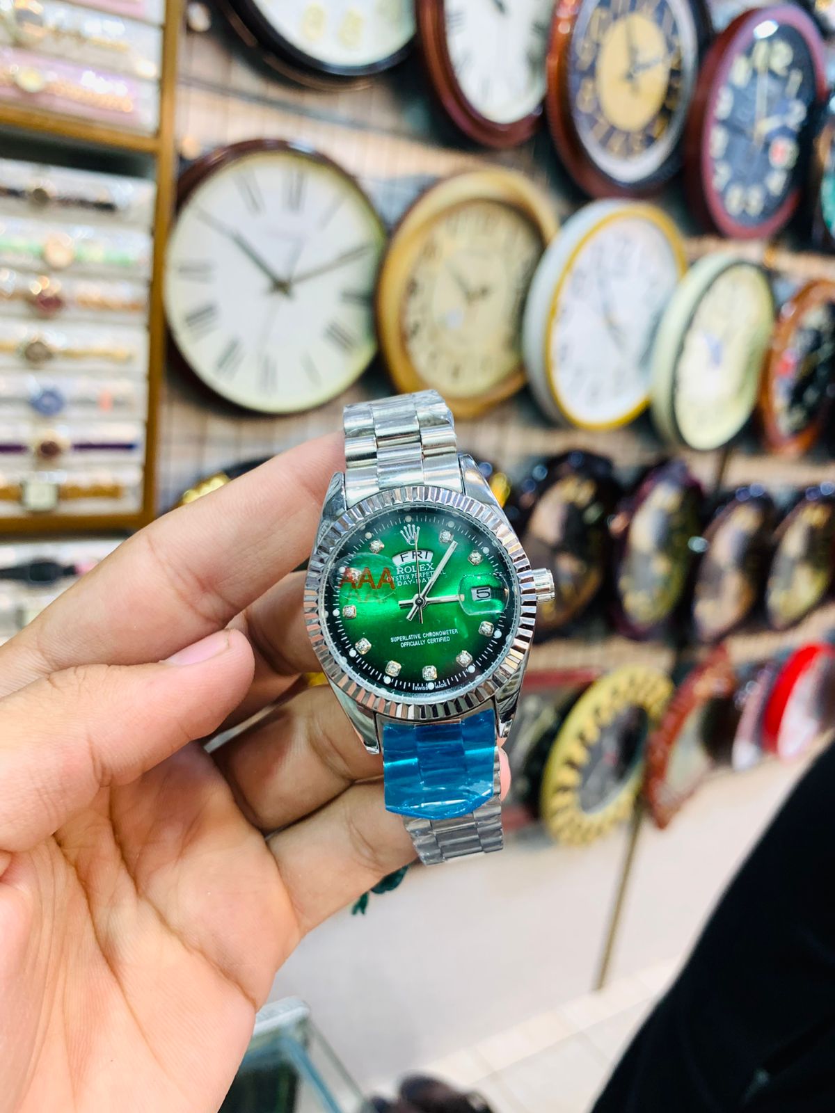 Luxury silver ladies wrist watch with emerald-green dial and glossy finish.