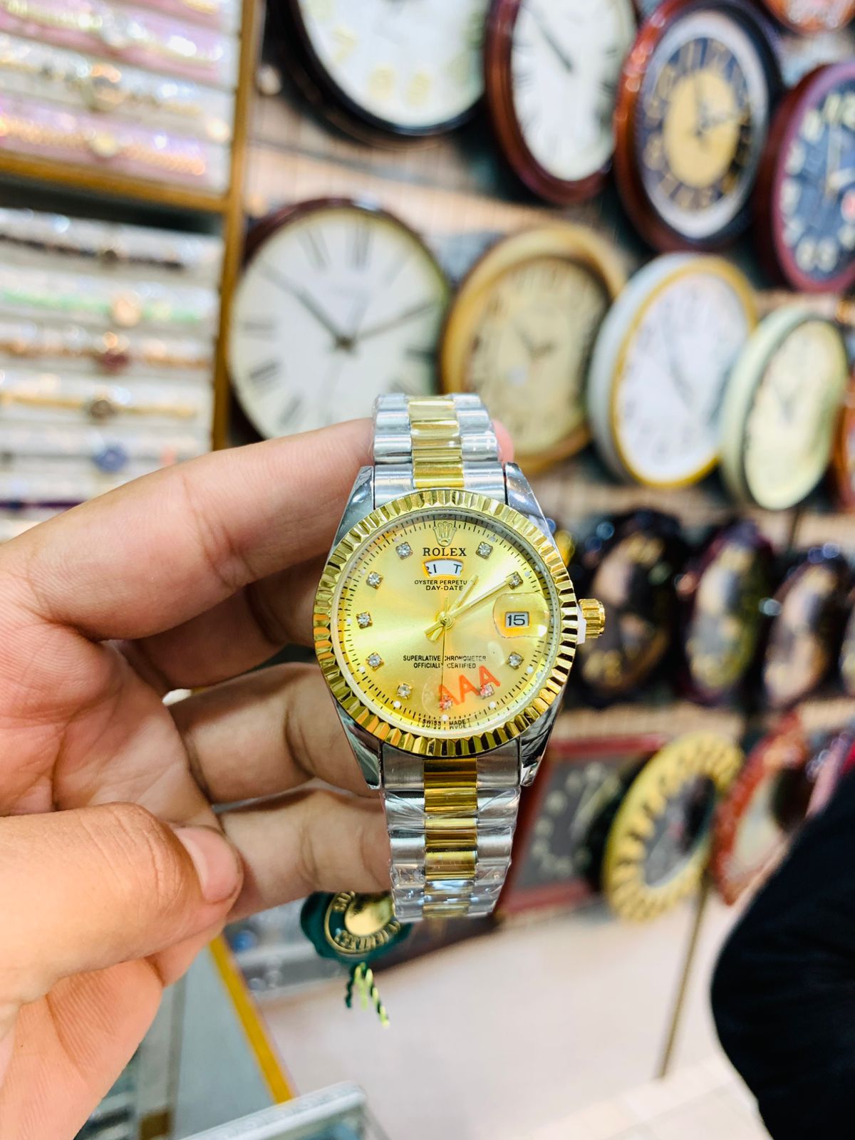 Premium two-tone wrist watch for women with gold dial and metallic strap.